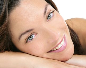 Attractive woman with smooth, youthful skin resting cheek on hand